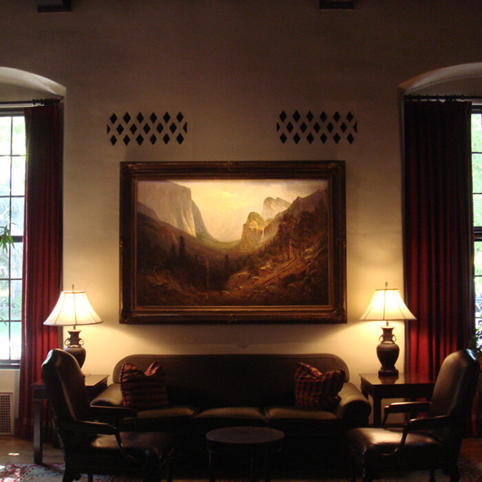 an image of a seating area in the Sutter Club Library Room with lamps illuminating the scene